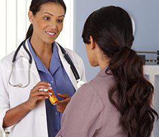 A doctor talking to a woman in an office.