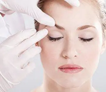 A woman getting her eyes examined by an eye doctor.