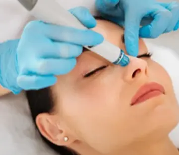 A woman getting her eyes cleaned by two hands.